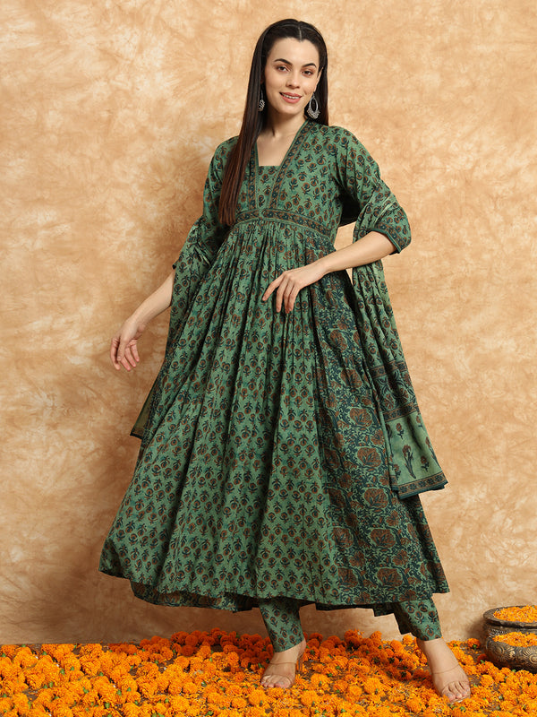 Woman in green floral maternity kurta set with dupatta, standing on marigold flowers