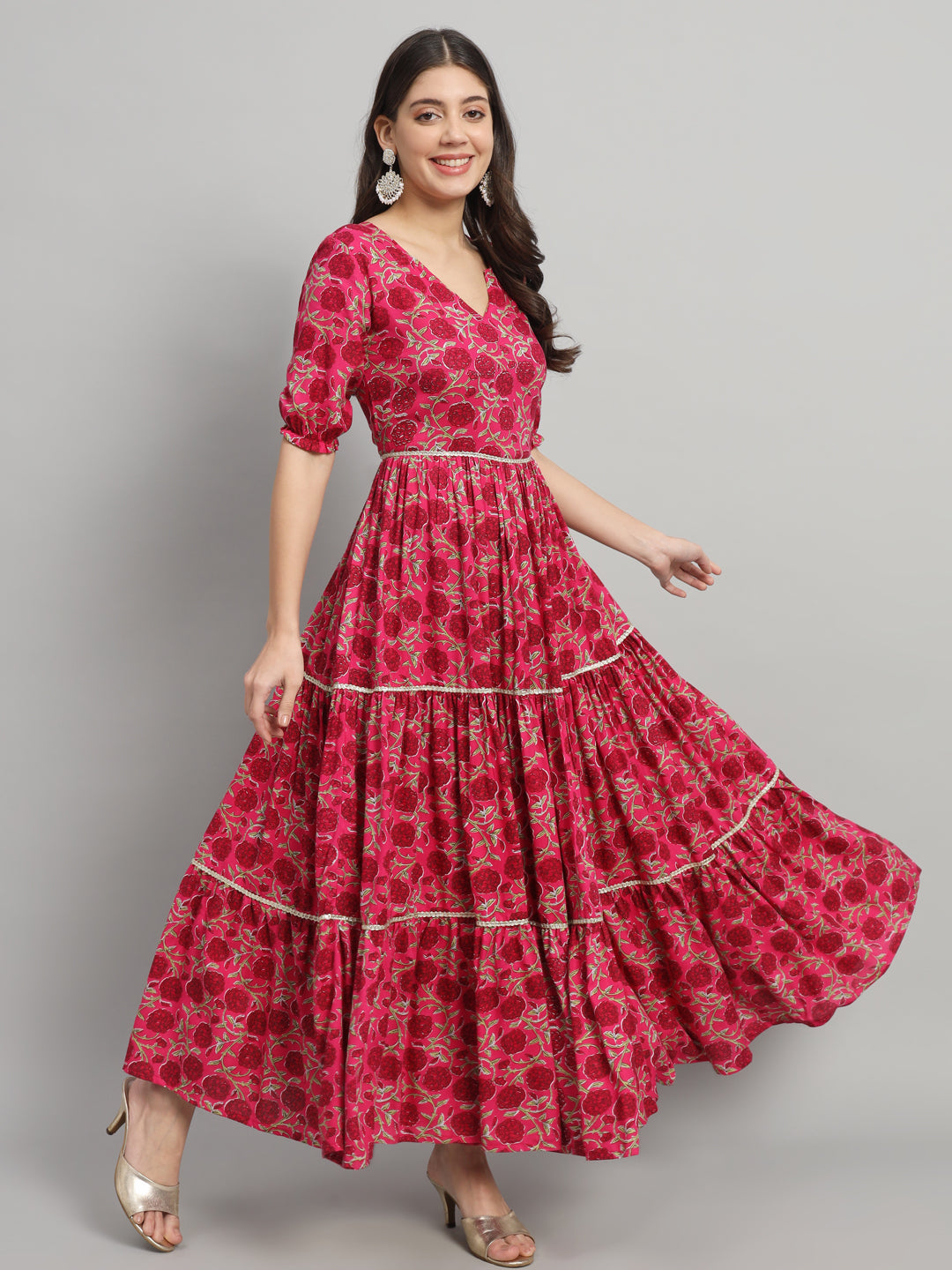 Woman in a pink floral maternity dress with dupatta, posing in front of gray background