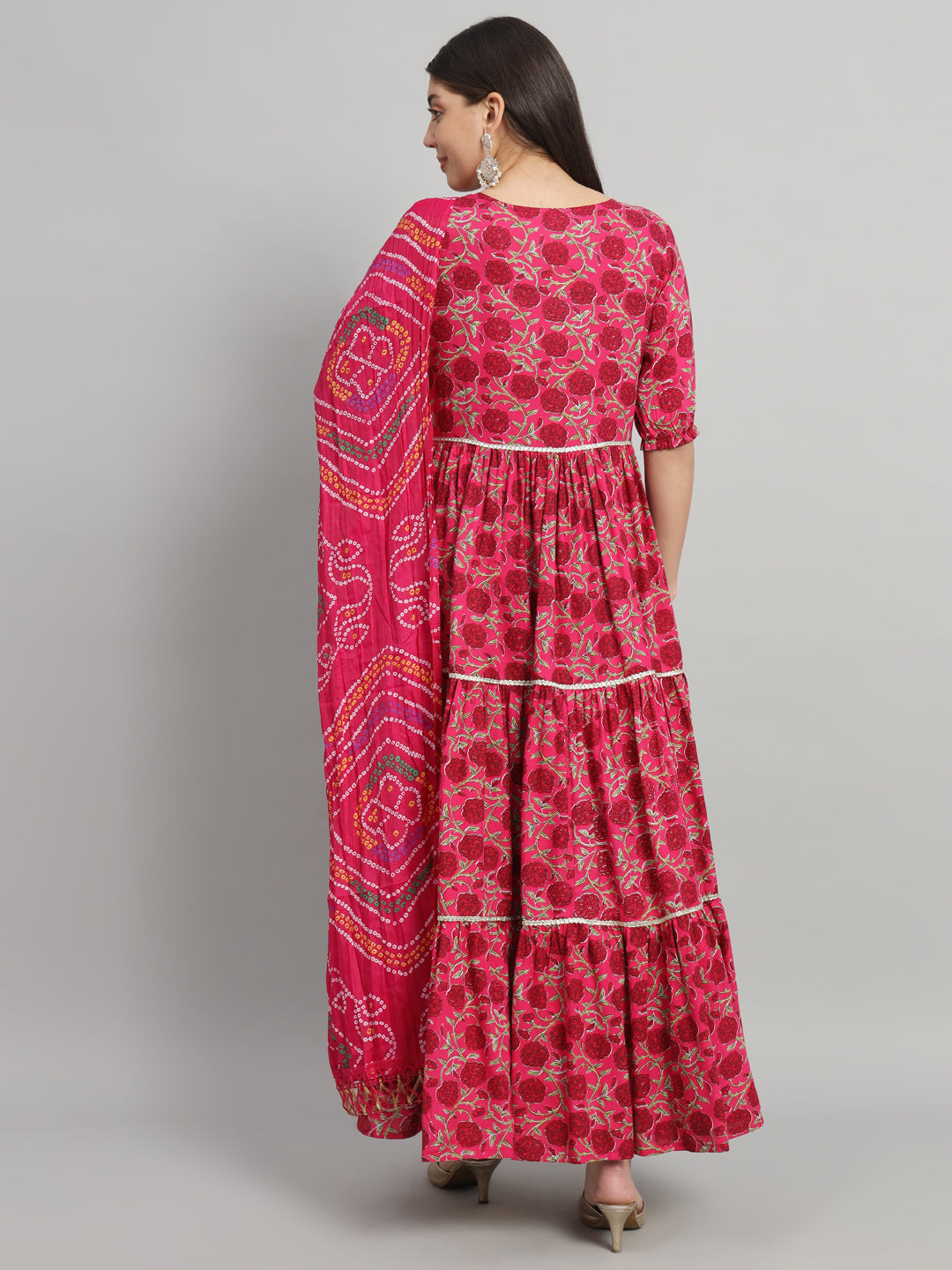 Woman in a pink floral maternity dress with dupatta and block heels, back view