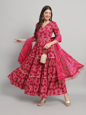 Woman in a pink floral maternity dress with dupatta, posing in front of gray background