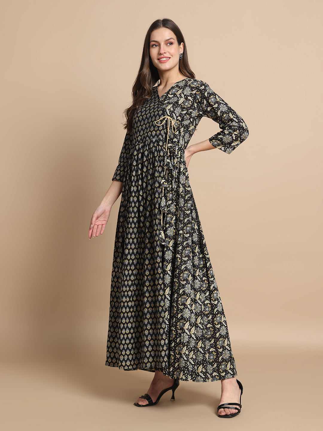 Woman wearing a black printed maternity dress with front tie detail, V-neck, and three-quarter sleeves