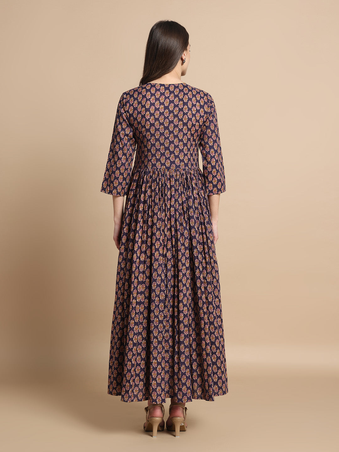 Woman wearing a navy blue floral maternity maxi dress with three-quarter sleeves, back view