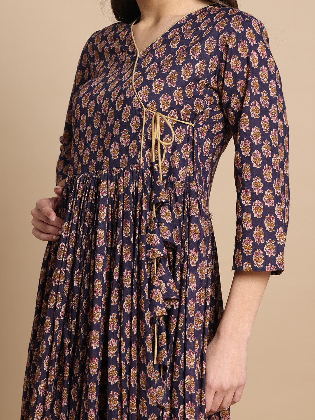Woman wearing a navy blue floral maternity dress with front tie and three-quarter sleeves