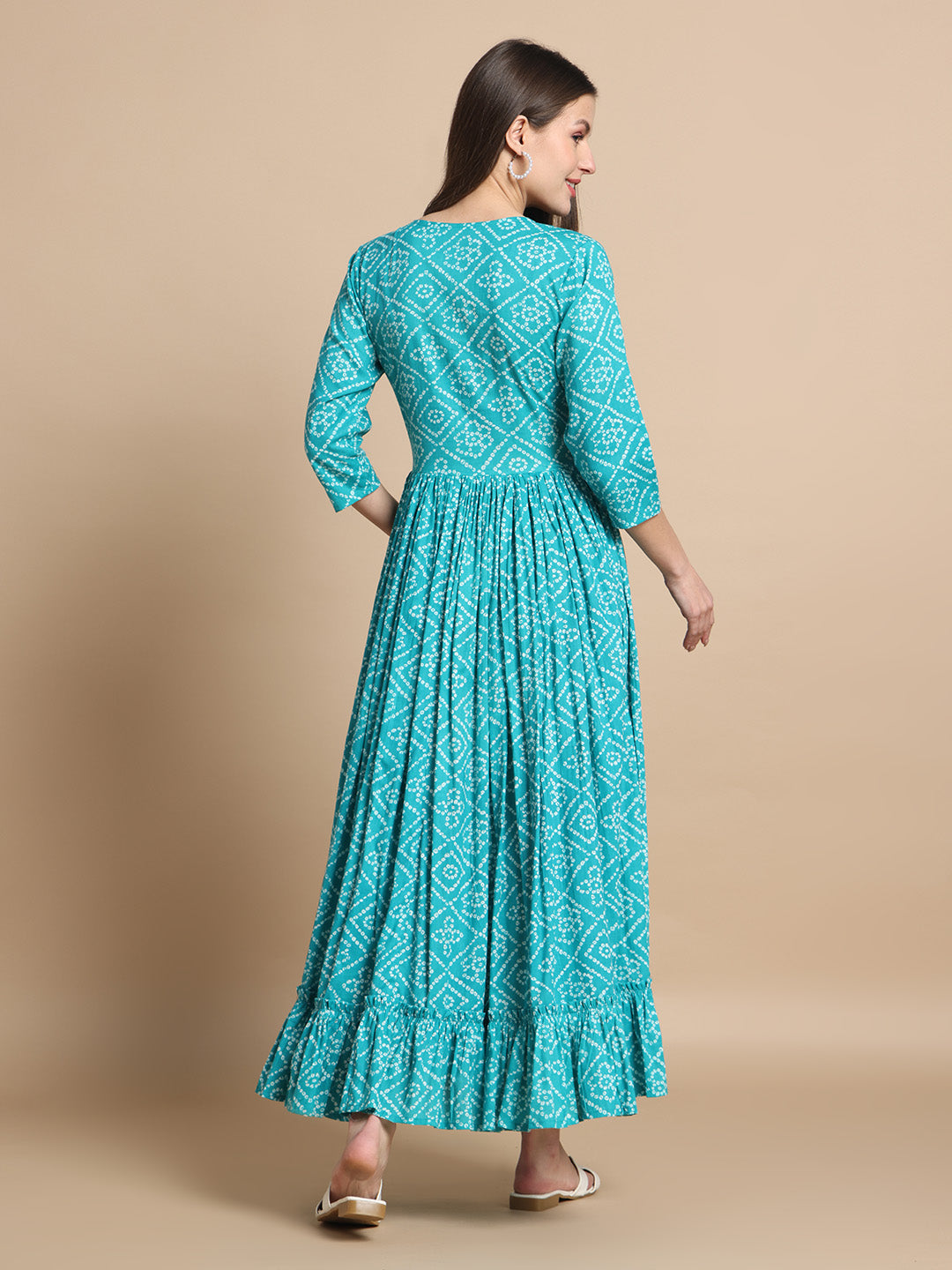 Woman in teal printed maxi maternity dress with three-quarter sleeves, back view