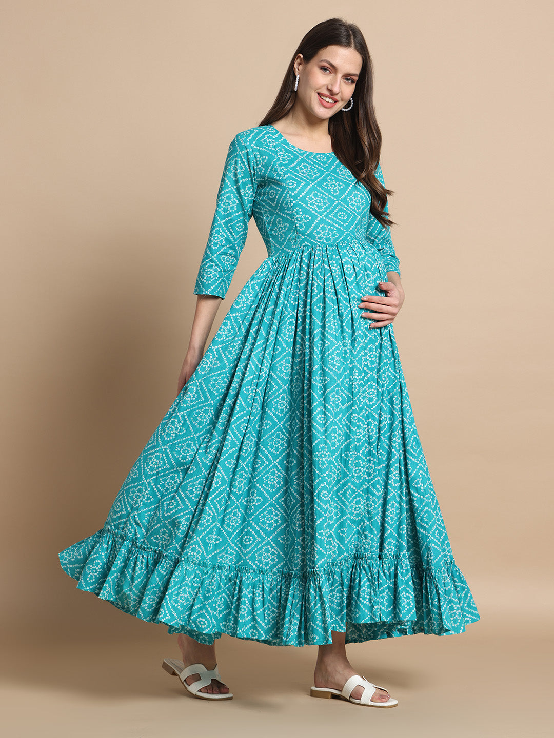 Pregnant woman in teal printed maternity maxi dress with three-quarter sleeves and ruffled hem