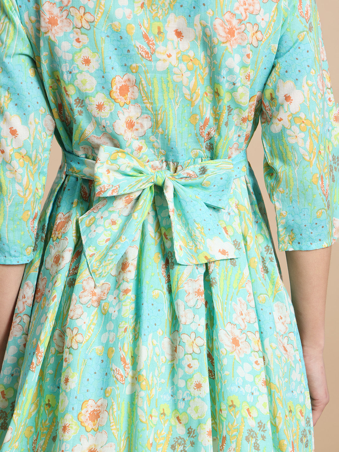 Close-up of back tie floral maternity dress in light blue with pastel flower print