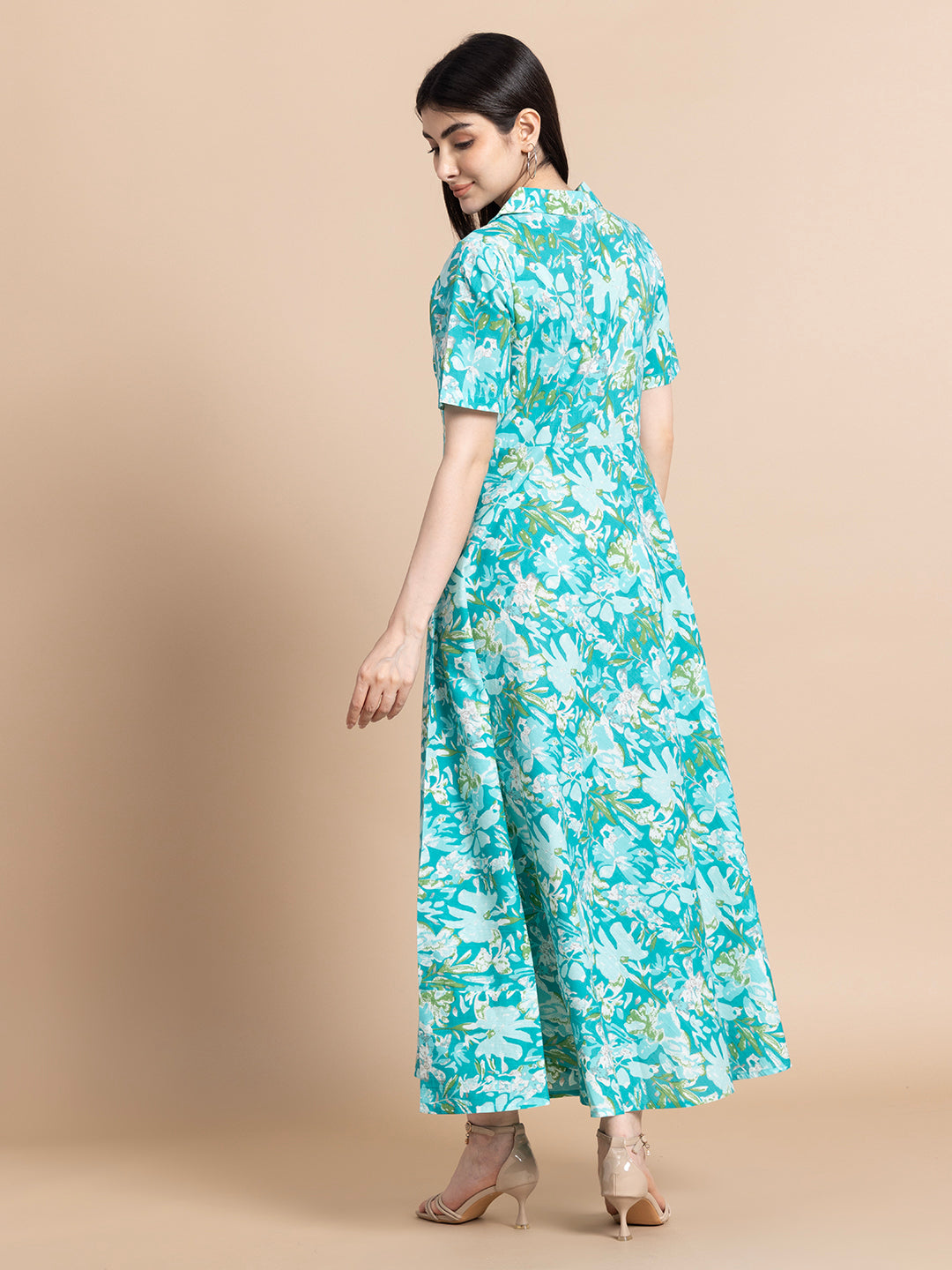Woman in a turquoise floral maternity maxi dress with short sleeves, viewed from the back