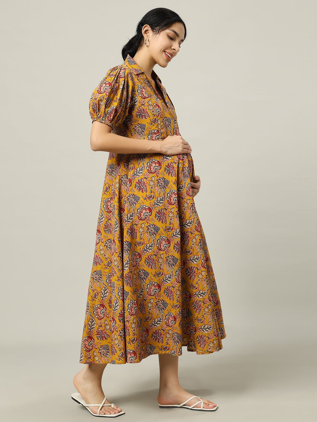 Pregnant woman in yellow floral print maternity dress with puff sleeves and collar
