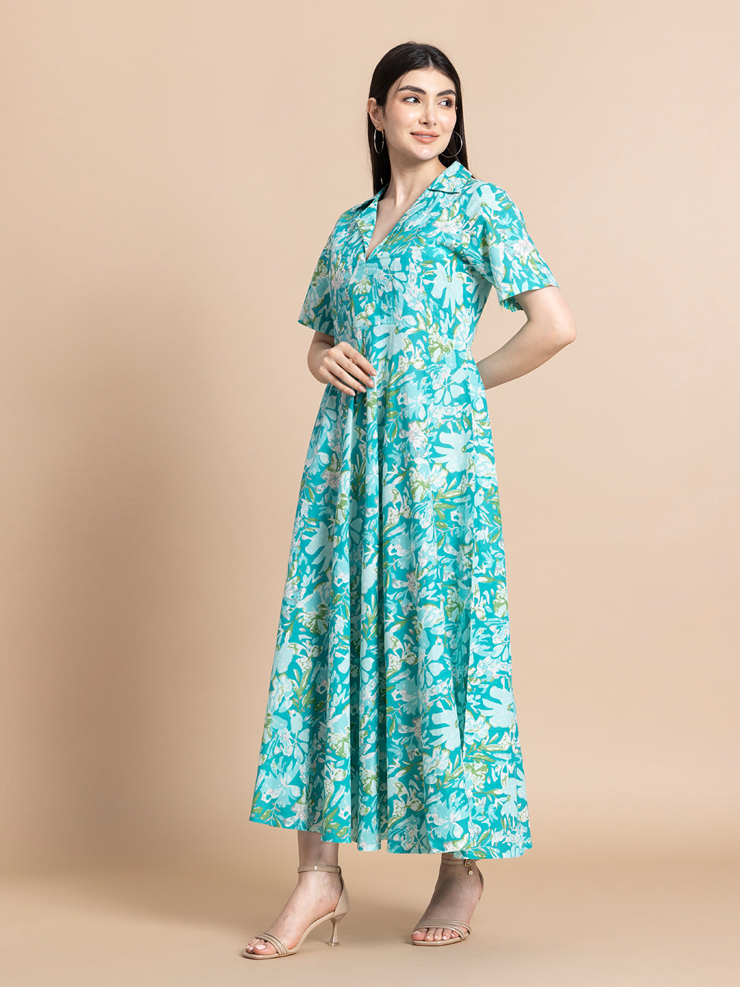 Woman wearing a turquoise floral maternity maxi dress with short sleeves and V-neck