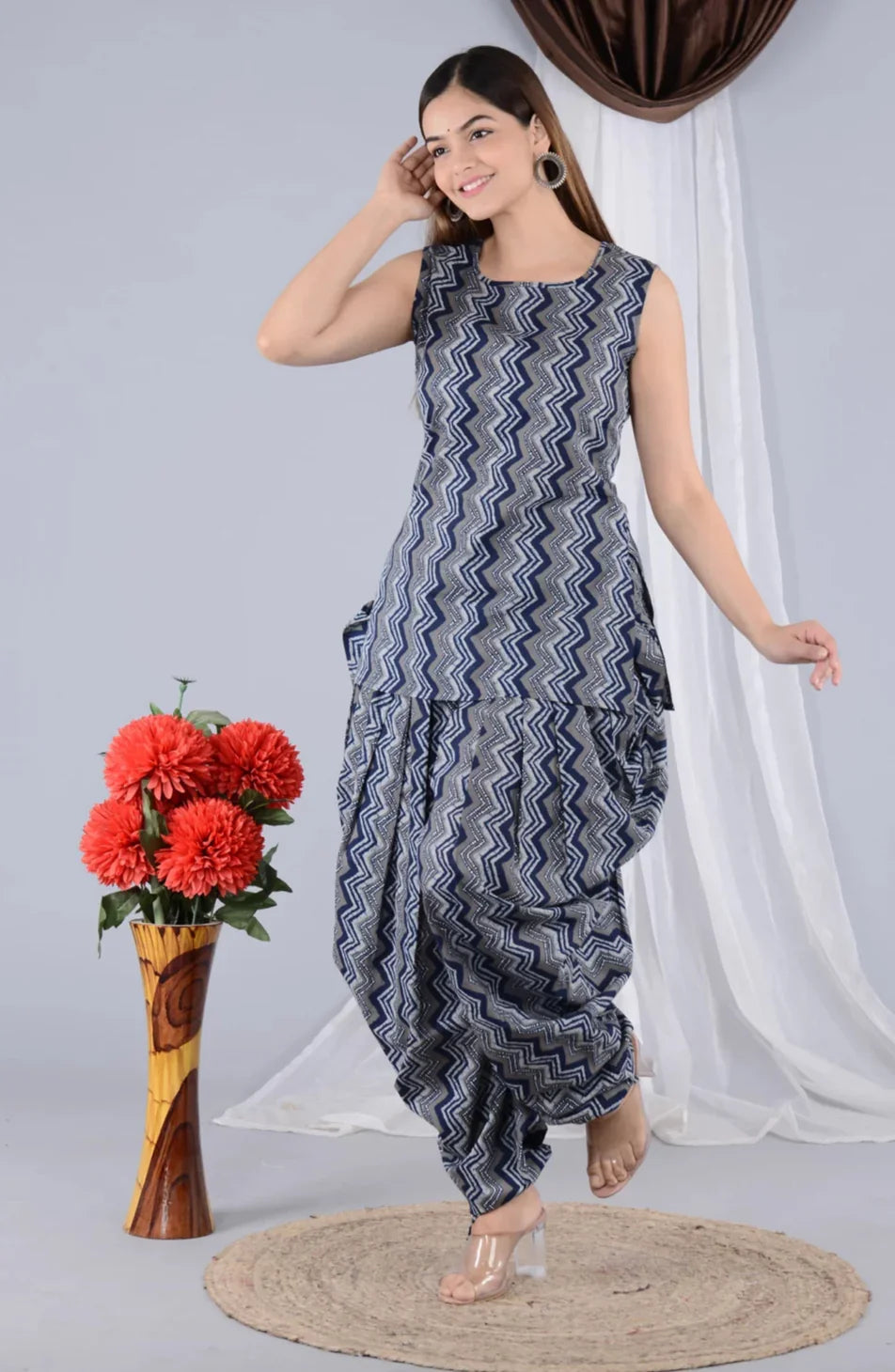 Woman in blue zigzag print maternity dhoti kurta set, posing indoors by red flowers