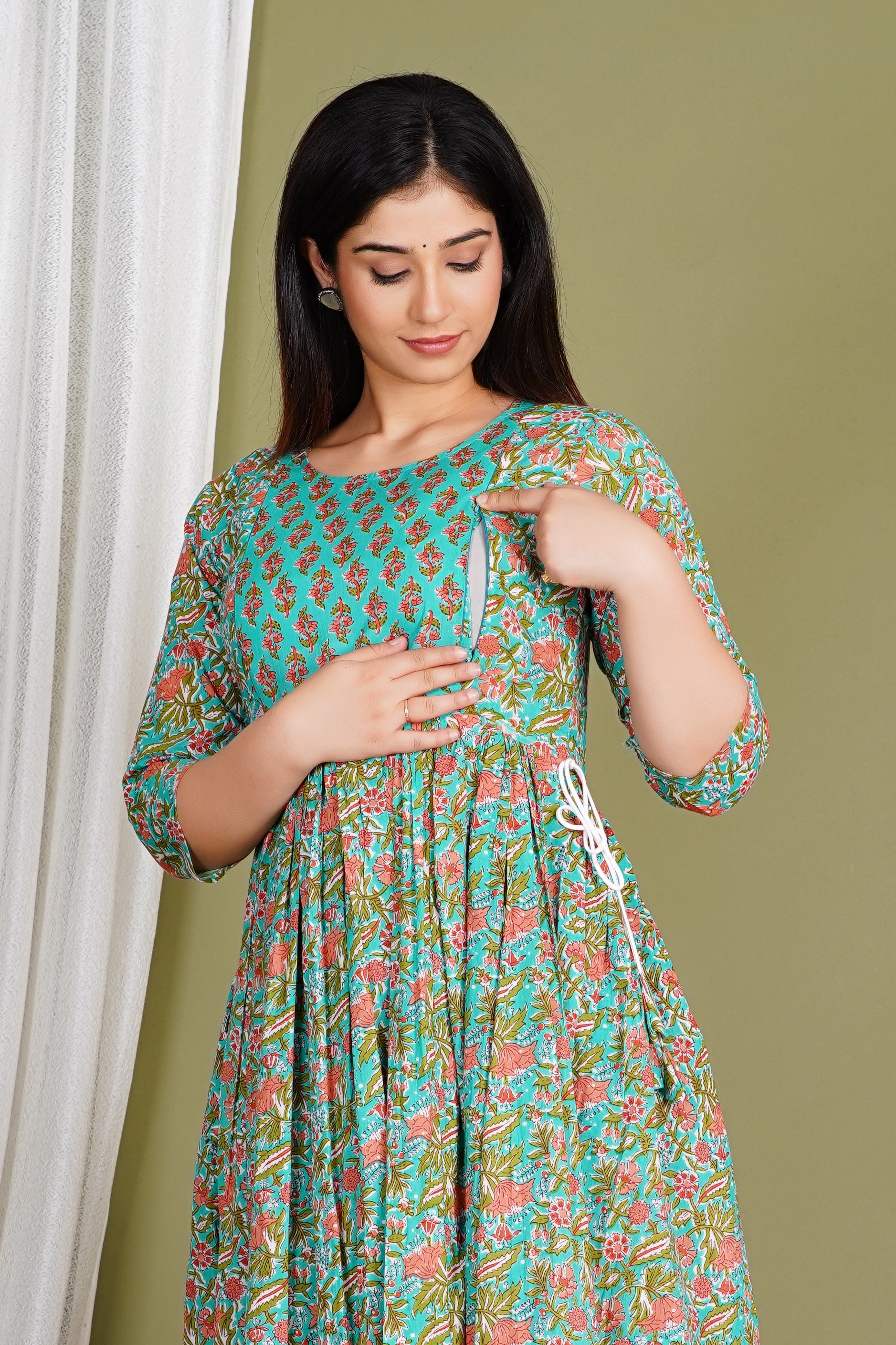 Woman wearing a floral cotton maternity and nursing dress with front zipper opening.