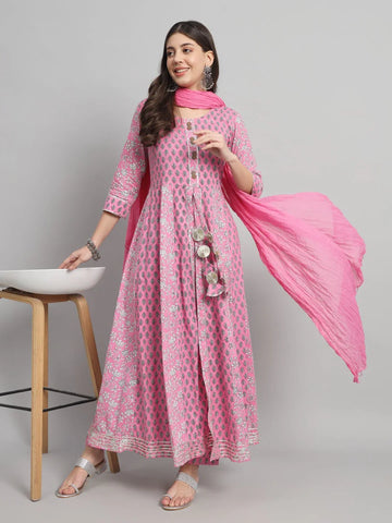 Woman wearing a pink printed kurta pant set with matching dupatta, silver sandals, and jewelry.